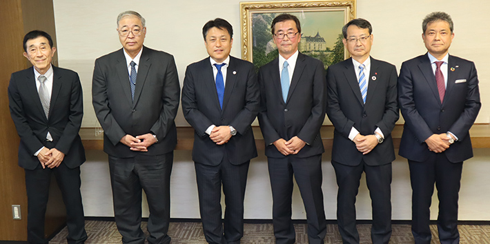 写真　正面左から廣岡事務局長、松浦専務理事、的場副会長、小澤会長、藤本副会長、岩田副会長